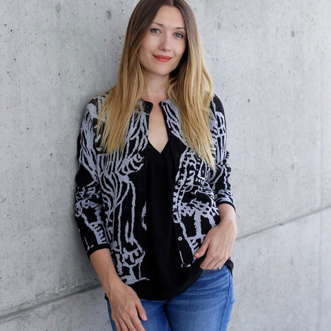 Cute, original fashion illustrations decorate this long sleeve, light weight cardigan, creating an almost abstract design. Accented with delicate pearl buttons.  100% soft cotton jacquard in a fine gauge makes this the perfect weight for all seasons. Pattern is also on back body.   Only available in black ground with heather grey pattern.  100% cotton Pearl buttons at front closure Fine gauge Allover pattern Machine wash cold, lay flat to dry.  cardigan sweater