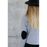 You are pert and pretty in a charming vintage-inspired cardigan. Smooth 100% cotton intarsia embellishes this soft knit, featuring two playful cats reaching for an embroidered butterfly. Accentuated by a detachable FAKE fur trim collar, appliqued elbow patches and delicate pearl buttons, this retro look inspires.  Heather grey with black pattern and collar.  100% cotton Detachable fur collar buttons on/off Appliquéd elbow patches Hand wash or machine wash gentle cycle Front button closure