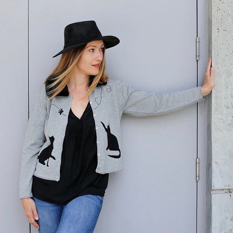 You are pert and pretty in a charming vintage-inspired cardigan. Smooth 100% cotton intarsia embellishes this soft knit, featuring two playful cats reaching for an embroidered butterfly. Accentuated by a detachable FAKE fur trim collar, appliqued elbow patches and delicate pearl buttons, this retro look inspires.  Heather grey with black pattern and collar.  100% cotton Detachable fur collar buttons on/off Appliquéd elbow patches Hand wash or machine wash gentle cycle Front button closure