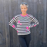 This graphic striped pullover features contrasting pink hearts artfully tossed.  100% soft cotton is in a fine gauge jacquard, suitable for all seasons. Details include jewel neck, long sleeves, and rib trims. Choose: Black/Off-White Stripe has bright pink hearts and neck trim.  or Black/Grey Heather Stripe has pale pink hearts and neck trim. 100% softest cotton Rib trims Fine gauge jacquard Machine wash cold, lay flat to dry.  Hearts and Stripes sweater